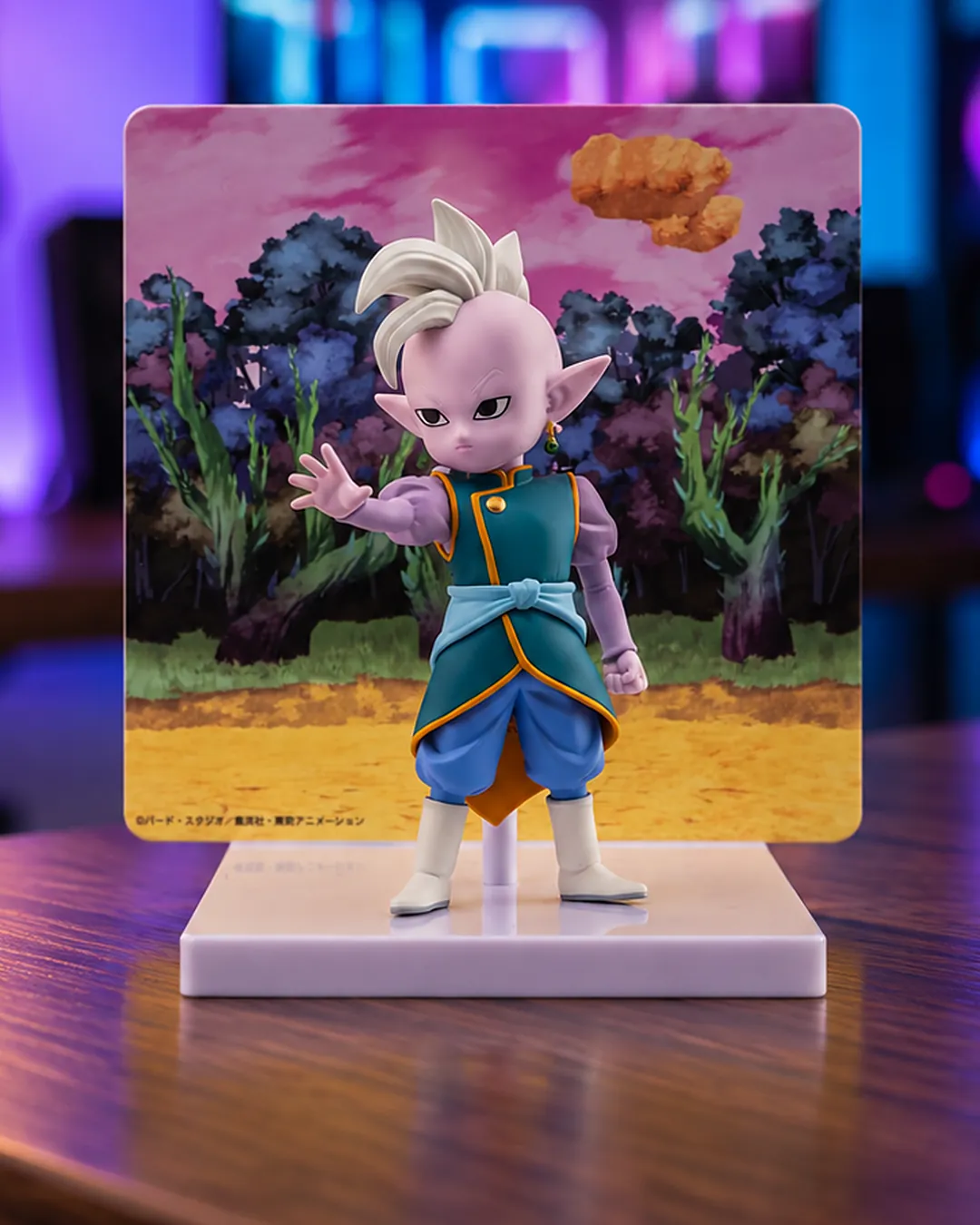 Supreme Kai en versión mini frente a su panel de fondo, figura de Banpresto de Dragon Ball Daima